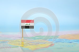 Selective focus of Iraqi flag in world map. Iraq country location and sovereignty concept.