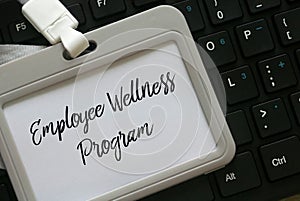 Selective focus of a keyboard and a lanyard with name tag written with Employee Wellness Program