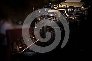 Selective focus on the keyboard and mechanism of an old black rustic typewriter on an office desk