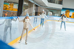 selective focus of kid skating on ice rink