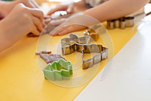 Selective focus. Kids making gingerbread cookies with various Christmas cookie cutters. Gingerbread dough. Family Christmas