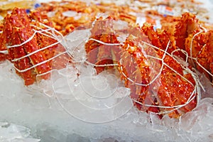Selective focus of king crab leg on ice at fish market. Portion of king crab leg ready to sell at seafood shop.