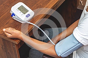 selective focus of a lady measuring blood pressure on a digital Sphygmomanometer.