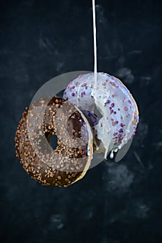 selective focus, levitating sweet doughnuts with chocolate and blueberry icing