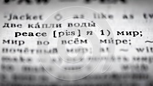 Selective focus on the line of an English-Russian dictionary giving the translation of the word `Peace` into Russian