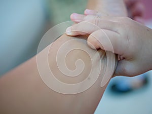 Selective focus of little baby`s hand pinching her father`s arm