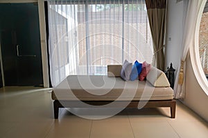 selective focus long fabric sofa bed with pillow in large living room in hotel villa for honeymoon