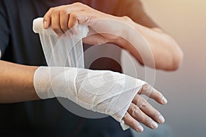 Selective focus of male applying bandage on his hand. People with home safety concept