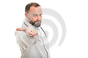 Selective focus of male doctor handing one pill