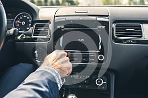 Selective focus of  man using car audio stereo system while driving his car.