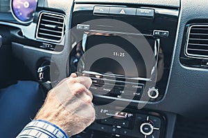 Selective focus of  man using car audio stereo system while driving his car.