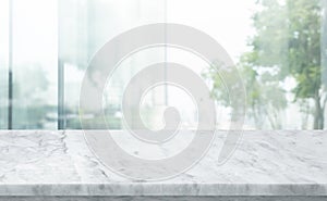 Selective focus.Marble table top on blur abstract cwindow glass background