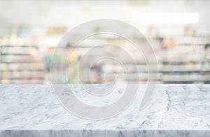 Selective focus.Marble table top on blur of supermarket product shelf background