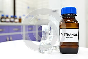 Selective focus of methanol brown amber glass bottle inside a laboratory. Blurred background with copy space.