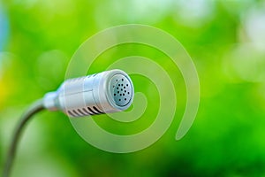 Selective focus of microphone on blurred green background