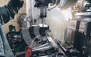 Selective focus on milling machine. Blurred worker is working on milling machine to milling metal plate. Tool for cut metal