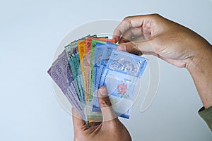 Selective focus at money with hand showing Malaysia banknotes, Ringgit Malaysia or Malaysia Ringgit Currency MYR