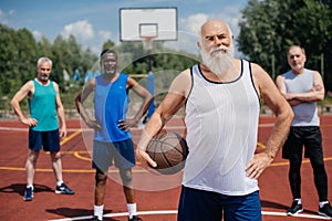 selective focus of multiethnic elderly sportsmen with basketball ball