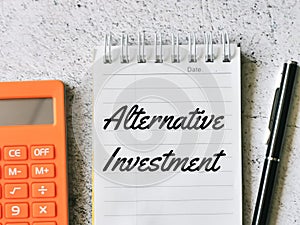 Selective focus notebook written alternative investment with pen and calculator.