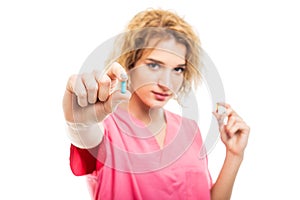 Selective focus of nurse wearing pink scrubs holding pills