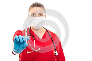Selective focus of nurse wearing red scrub showing syringe