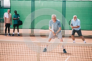 selective focus of old sportsmen playing tennis