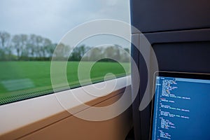 Open laptop or notebook, working as programmer and do some coding on the train during commute.
