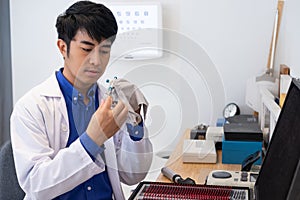 Selective focus at optometrist face. Asian Doctor optometrist using trail glasses equipment to examine eye sight visual system of