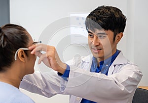 Selective focus at Optometrist face. While doctor using Optometry equipment and trial glasses frame  to examine eye visual system