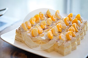 Selective focus of Orange sponge cake on white dish on the buffet table
