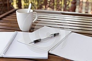 Selective focus of Pen, notebook , coffee cup on the wooden table and copy space