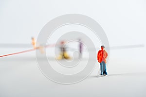 Selective focus of people figure near dolls and arrows of clock on white surface photo