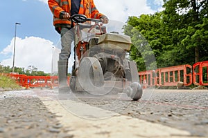 selective focus of the petrol powered road saw with dimond blade cutting asphalte road surface