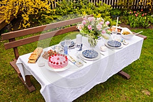 Berry cake and decorated dinner table in garden