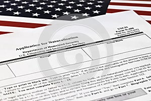 Selective focus photo of n-400 form. application for naturalization, on a background of United States flag