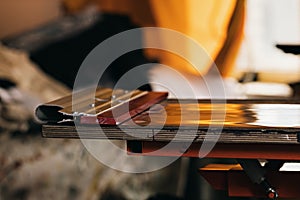 Selective focus photo of a squeegee on wooden shelve of the print screening apparatus. serigraphy production. printing images on t