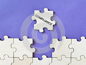 Selective focus phrase compliance on wooden jigsaw puzzle