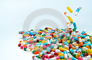 Selective focus on pile of antibiotic capsule pills. Colorful antibiotic capsules pill falling on white table. Antibiotic drug