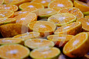 In selective focus a pile of fresh oranges cut in a half