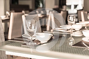 Selective focus point on wine glass with table setting for dinning in hotel restaurant