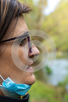 Selective focus of a portrait of a middle-aged woman with glasses looking at nature in a sunset