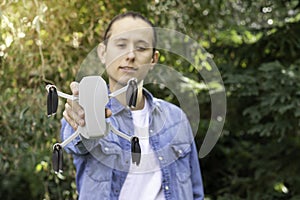 Selective focus portrait of a portable quadricopter drone with 4K camera held in his hand of a young boy