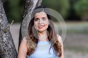 Selective focus portrait of a smiling middle-aged latina woman in a park