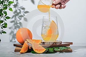 Selective focus, pouring orange soda into glass on white background. soft drink is fresh summer drink in the morning, iced orange