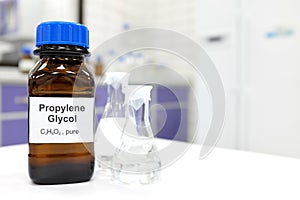 Selective focus of propylene glycol liquid chemical compound in dark glass bottle inside a chemistry laboratory with copy space. photo