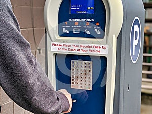 Selective focus on a public parking payment meter as a person makes a payment