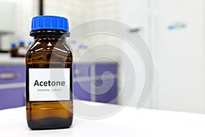 Selective focus of pure acetone solution in brown glass amber bottle inside a chemistry laboratory. White background. photo