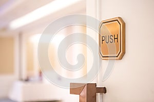 Selective focus of Push sign on the white door of the seminar room