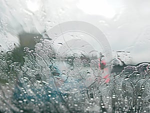 Selective focus of rain on the windshield of a car on a rainy day - driver`s perspective
