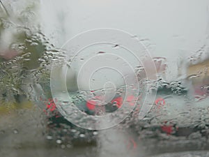 Selective focus of rain on the windshield of a car on a rainy day - driver`s perspective